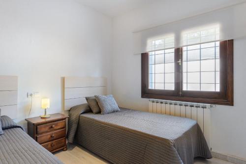 a bedroom with two beds and a window at Villa Can Carreras in Sant Llorenç de Balafia