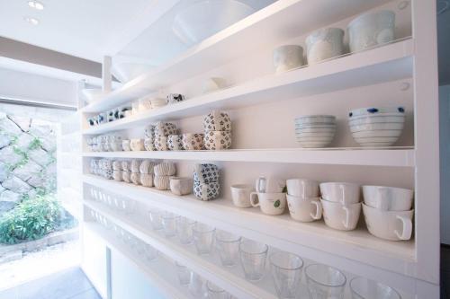 a shelf with cups and bowls on it at DogoYaya in Matsuyama