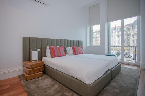 a bedroom with a large bed and a large window at Liiiving in Porto | Aliados Luxury Apartments in Porto