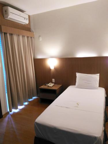 Una cama o camas en una habitación de Sete Lagoas Residence Hotel
