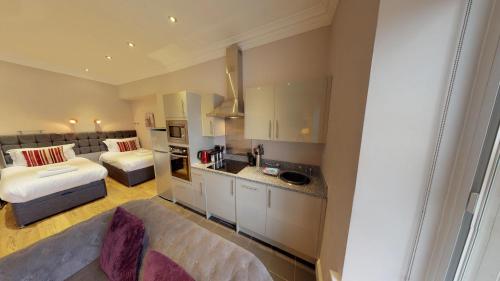 a small room with a bed and a kitchen and a bedroom at Harrogate Lifestyle Luxury Serviced ApartHotel in Harrogate