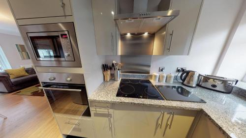 a kitchen with a sink and a stove at Harrogate Lifestyle Luxury Serviced ApartHotel in Harrogate