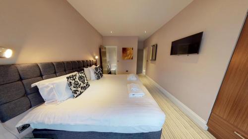 a bedroom with a large bed with a large headboard at Harrogate Lifestyle Luxury Serviced ApartHotel in Harrogate