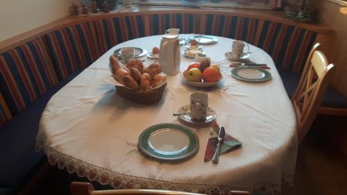 a table with a white table cloth and a basket of fruit at Ferienwohnung Greim in Sankt Peter am Kammersberg