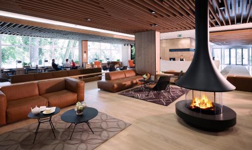 - un hall avec un canapé et une cheminée dans l'établissement Rikli Balance Hotel – Sava Hotels & Resorts, à Bled