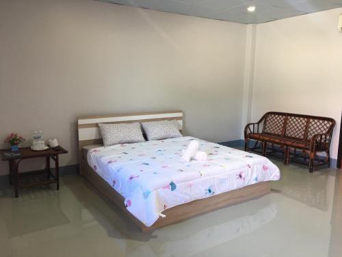 a bedroom with a large bed with two chairs at Muangchaem House in Mae Chaem