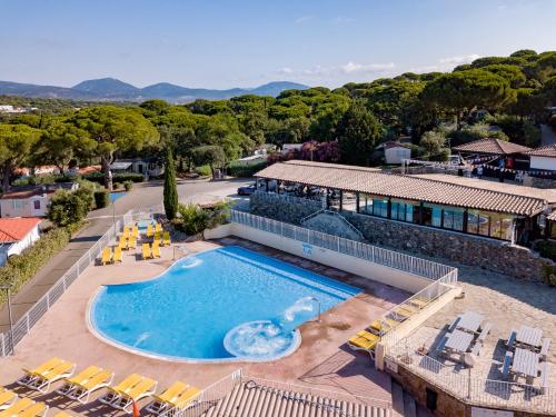 - une vue sur une piscine avec des chaises et un bâtiment dans l'établissement PARC ST JAMES PARC MONTANA, à Gassin