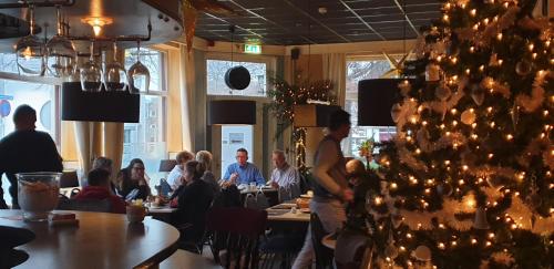 a christmas tree in a restaurant with people sitting at tables at De Zevende Hemel in Kerkrade