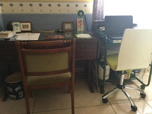 un bureau avec un bureau, un ordinateur et une chaise dans l'établissement Chambre et pièce confort, à La Possession