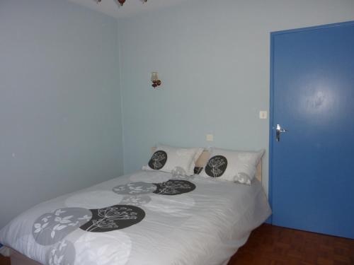 a bed with black and white pillows on it at Le cerisier in Millau