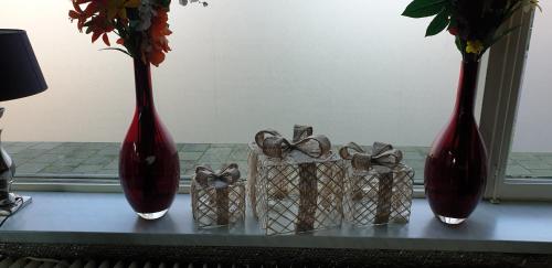 three red vases sitting on a table with gifts at De Zevende Hemel in Kerkrade