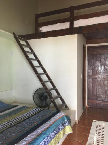 a room with a bunk bed with a ladder on the wall at CASA À BEIRA MAR EM PRAIA DE CAMPINA in Rio Tinto