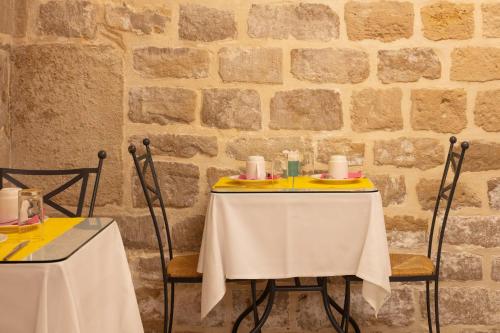 two tables in a restaurant with white table cloth at Hotel Palm - Astotel in Paris