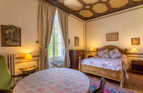 - une chambre avec un lit et une table dans l'établissement Château de Mont-Félix, à Saint-Jean-Saint-Germain