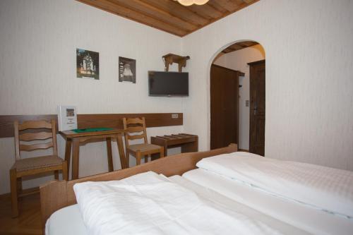 een slaapkamer met een bed en een tafel met een stoel bij Gasthof Maurer in Gloggnitz