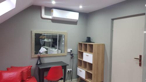 a room with a red chair and a desk and a mirror at Zacisze in Sokółka