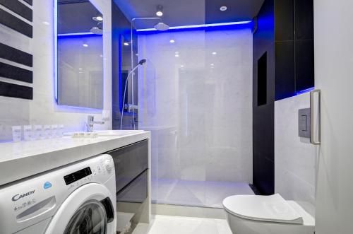 a bathroom with a washing machine and a toilet at Dom & House - Apartments Karlikowska Sopot in Sopot