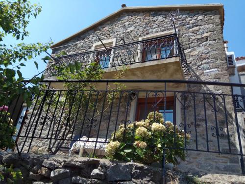 a building with a balcony with flowers on it at Villa Aleka in Samothráki