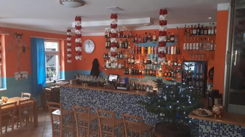a bar with a christmas tree in a restaurant at Apartmány KOS in Pec pod Sněžkou
