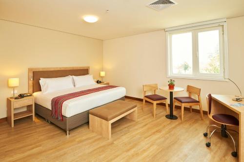 a hotel room with a bed and a desk at Hotel Estelar San Isidro in Lima