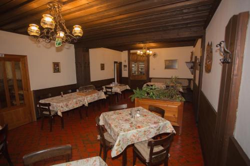 a restaurant with tables and chairs and a chandelier at Gasthof Maurer in Gloggnitz