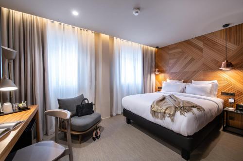 a hotel room with a bed and a desk and a chair at 9Hotel Paquis in Geneva