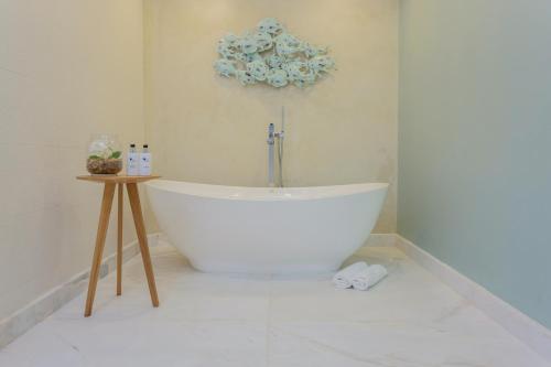 a white bath tub in a white bathroom at Views Boutique Hotel & Spa in Wilderness