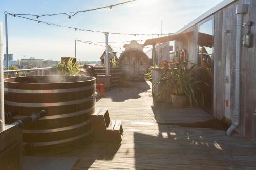 um passadiço de madeira com vasos de plantas num edifício em Volkshotel em Amsterdã