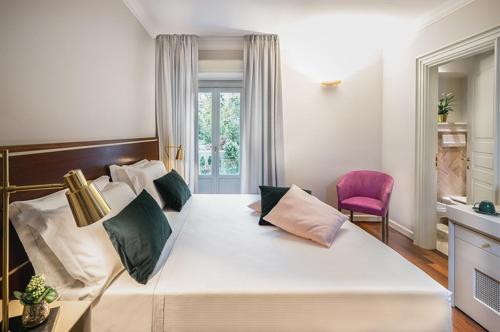 a bedroom with a large white bed with a red chair at Magville in Milan