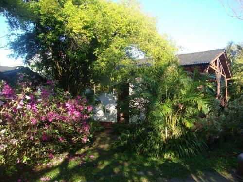 a house with trees and flowers in a yard at Pousada do Pescador in Florianópolis