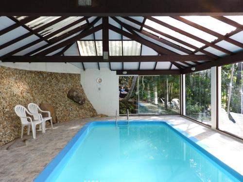 a swimming pool in a house with a roof at Pousada do Pescador in Florianópolis