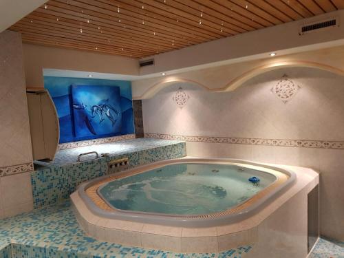 a bathroom with a jacuzzi tub in a room at Typically Swiss Hotel Täscherhof in Täsch