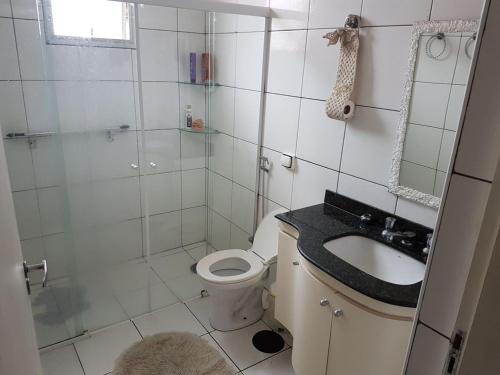 a bathroom with a toilet and a shower and a sink at Apt. Enseada Guarujá in Guarujá