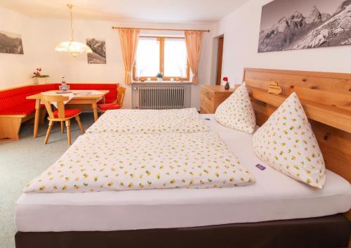 a bedroom with two beds and a table at Gästehaus Schmid in Obermaiselstein