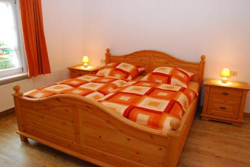sypialnia z drewnianym łóżkiem i 2 szafkami nocnymi w obiekcie Ferienhaus Becker w mieście Schönau