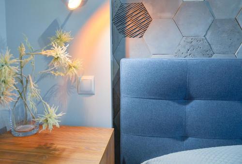 a bedroom with a blue bed and a wooden table at Apartamenty Na Wyspie - Baltic Park - Apartamenty z sypialnią i parkingiem - ul Uzdrowiskowa 24-34 in Świnoujście