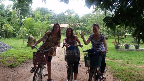 drei Frauen fahren mit Fahrrädern auf einem unbefestigten Weg in der Unterkunft Udesh Guest in Polonnaruwa