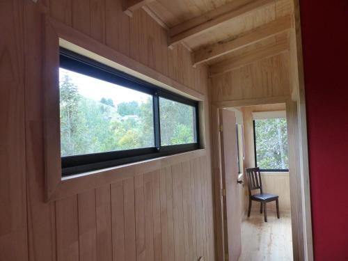 a room with a window and a chair in a house at Cabañas Latitud 41 Sur in Quillaipe