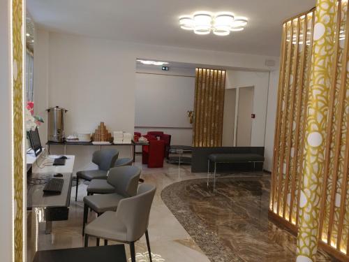 a lobby with a waiting room with chairs and tables at Hotel Aida Opera in Paris