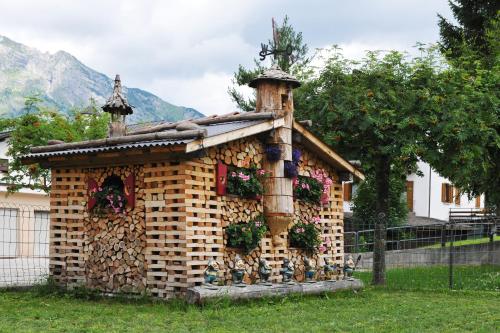 a house made out of bricks in a yard at Cavallino Lovely Hotel in Andalo