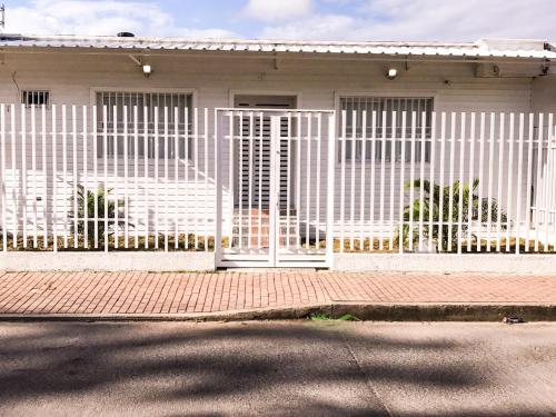 una cerca blanca frente a una casa en Tropical Breeze Aeropuerto, en San Andrés