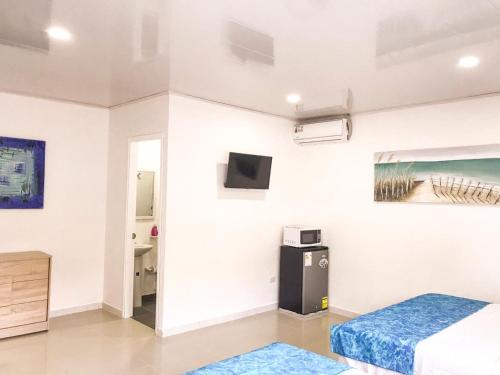 um quarto com uma cama e uma televisão na parede em Tropical Breeze Aeropuerto em San Andrés