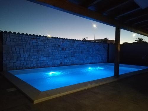 a swimming pool at night with a brick wall at B&b A Due Passi Dal Sole in Porto Empedocle