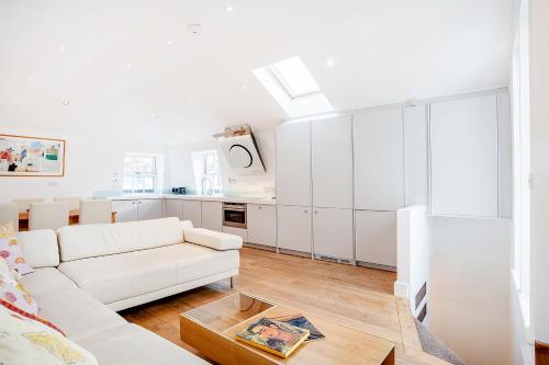 uma sala de estar branca com um sofá branco e uma mesa em Beautiful 2 bedrooms apartment in Knightsbridge em Londres