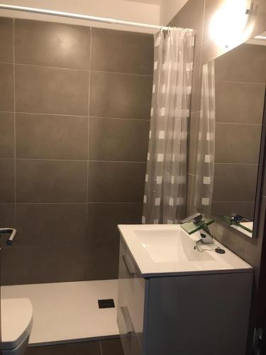 a bathroom with a sink and a toilet and a mirror at Medano Beach Villas in El Médano