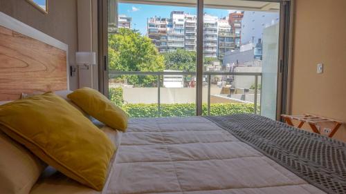 a bedroom with a large bed and a large window at Privilege Studios in Terrazas Polo in Buenos Aires