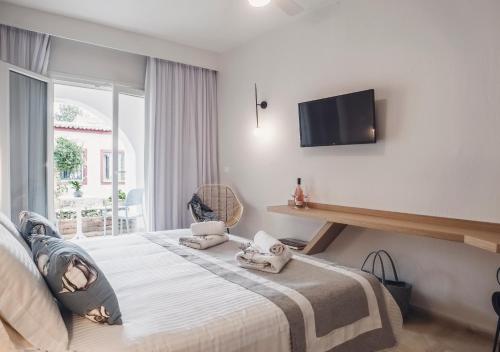 a bedroom with a bed with a tv on the wall at Iliada Beach Hotel in Gouvia