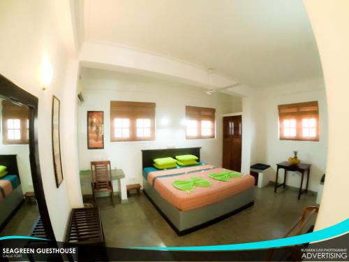 a bedroom with a bed with yellow pillows on it at Seagreen Guesthouse in Galle