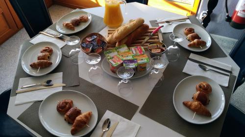 une table avec des assiettes de nourriture et des verres de jus d'orange dans l'établissement Les Remparts - chez Dan et Francois, à Bénévent-lʼAbbaye
