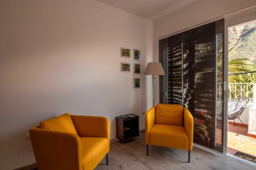 two yellow chairs in a room with a window at Casa La Alameda,Valle Gran Rey, La Gomera in Valle Gran Rey